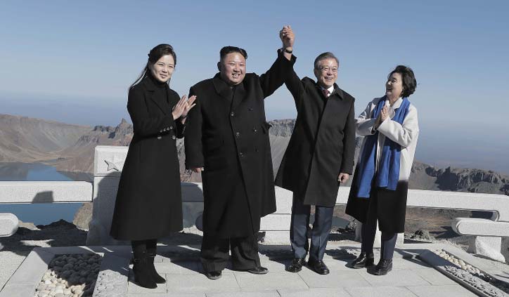 Kim Jong Un, Moon Jae-in join hands on peak of sacred North Korean volcano