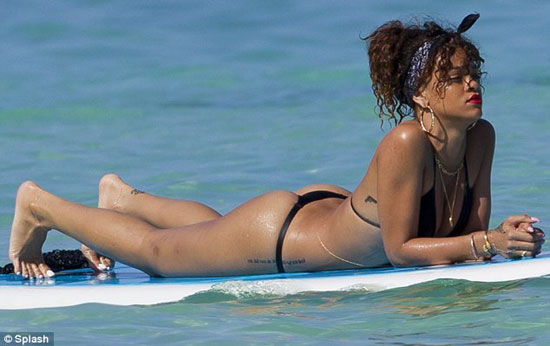 Rihanna shows off her pert derriere in a G-string bikini
