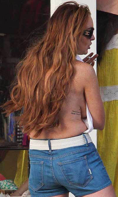 Lindsay Lohan shows sideboob, struggles to defy gravity in backless halterneck top