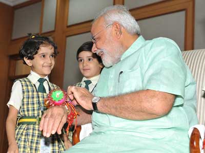 Women and children tie Rakhi on PM's wrist on the occasion of Raksha Bandhan